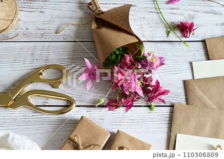 Pink and blue flowers, postcard, kraft, twine. Layout of Women's Day or Mother's Day, St. Valentine's Day, flat, top view. Pink and blue flowers, postcard, kraft, twine. Layout of Women's Day or Mother's Day, St. Valentine's Day, flat, top view. 110306809