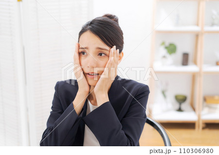頭をおさえるスーツの女性 頭をおさえるスーツの女性 110306980