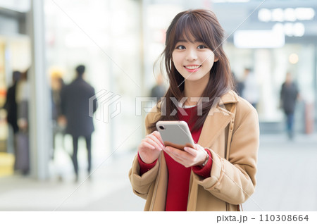 スマホを手に持ち待ち合わせをする若い女性:AI生成画像 スマホを手に持ち待ち合わせをする若い女性:AI生成画像 110308664