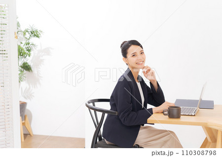 オフィスでパソコンを使う笑顔のビジネスウーマン 110308798