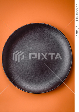 Empty round ceramic plate on a plain background, flatley with copy space 110309977