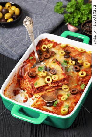lasagna with olive rings in green baking dish lasagna with olive rings in green baking dish 110310232