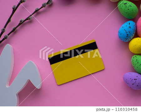 Shopping cart with colorful eggs, credit card on pink background with copy space Shopping cart with colorful eggs, credit card on pink background with copy space 110310458