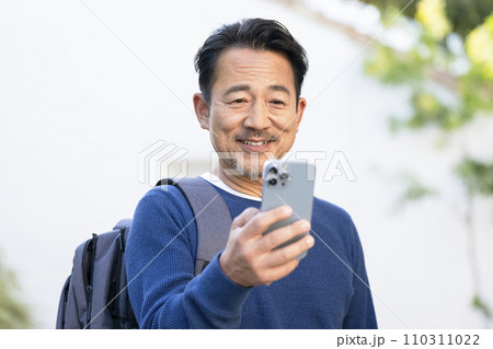スマートフォンの画面を見る50代の男性 110311022
