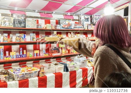 夜店で射的をする女性 110312736