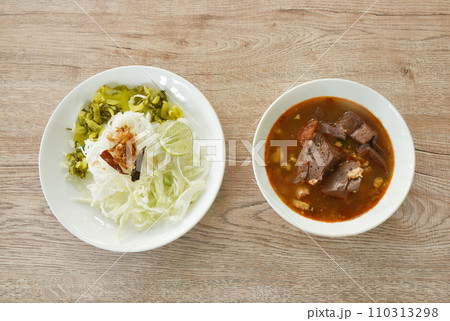 rice noodles fresh pickled and fresh cabbage eat with spicy chop pork and blood couple red cotton tree in curry sauce on plate rice noodles fresh pickled and fresh cabbage eat with spicy chop pork and blood couple red cotton tree in curry sauce on plate 110313298