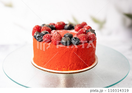 Red cake with raspberries and blueberries on a light background. 110314319