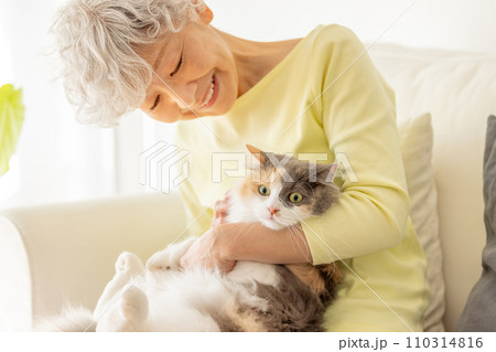 家で猫を抱っこする日本人シニア女性（猫・飼い主） 110314816