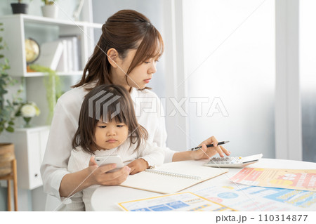 子供の教育費を計画する真剣な母親 子供の教育費を計画する真剣な母親 110314877