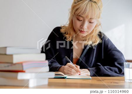 夢に向かい勉強をする金髪の若い女性 110314960