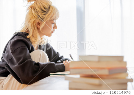 夢に向かい勉強をする金髪の若い女性 夢に向かい勉強をする金髪の若い女性 110314976