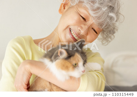 家で猫を抱っこする日本人シニア女性(猫・飼い主) 家で猫を抱っこする日本人シニア女性(猫・飼い主) 110315449