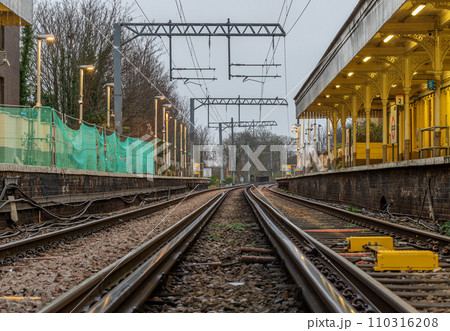 Perspective view on empty railway tracks and electric infrastructure equipment, wires at Acton central rail station. Perspective view on empty railway tracks and electric infrastructure equipment, wires at Acton central rail station. 110316208