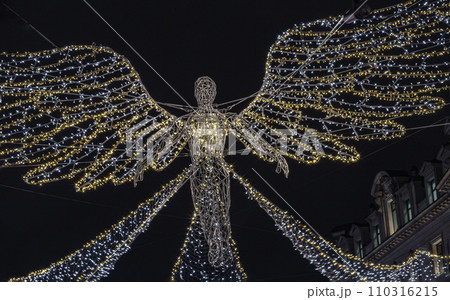 Flying angel Christmas decoration led lights display. Dramatic view of the traditional Christmas decoration lights hanging above Regent Street during dusk. 110316215
