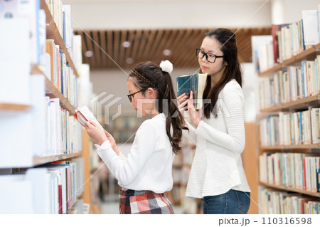 本を選ぶ親子 110316598