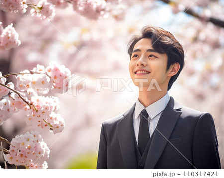満開の桜とリクルートスーツの笑顔の男性 満開の桜とリクルートスーツの笑顔の男性 110317421
