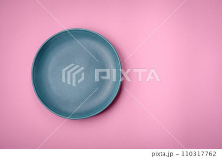 Empty round ceramic plate on a plain background, flatley with copy space Empty round ceramic plate on a plain background, flatley with copy space 110317762