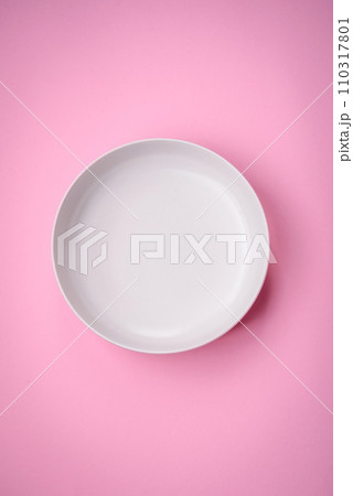 Empty round ceramic plate on a plain background, flatley with copy space 110317801