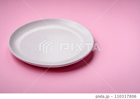 Empty round ceramic plate on a plain background, flatley with copy space 110317806