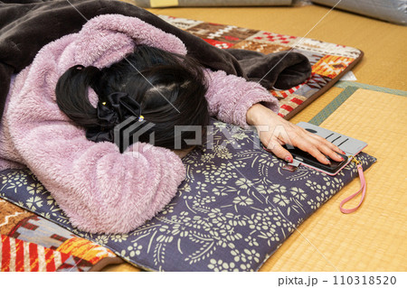 和室のこたつで昼寝をする女性 110318520
