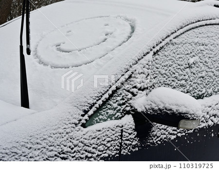 A snow covered car with a smiley face on it A snow covered car with a smiley face on it 110319725