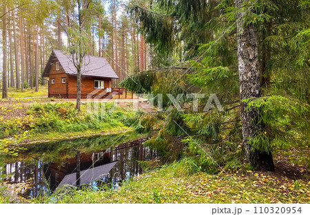 A wooden house in the forest in a sunny day A wooden house in the forest in a sunny day 110320954