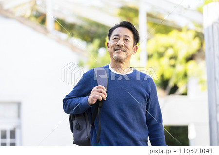 リュックを肩にかけた中年男性　 110321041