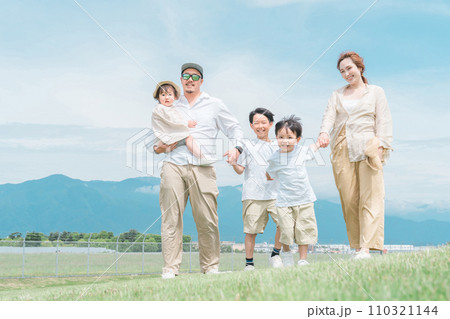 家族旅行・春・夏に青空の見える公園で遊ぶ家族・ファミリー・親子 110321144
