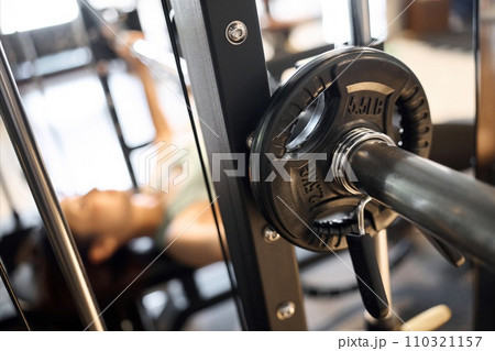 バーベルベンチプレスで胸を鍛える女性 110321157