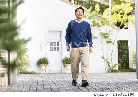 リュックを肩にかけて歩く50代の男性 リュックを肩にかけて歩く50代の男性 110321294