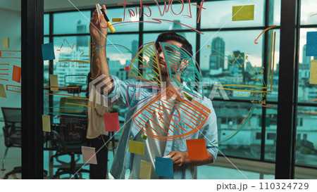 Businessman uses sticky notes at glass wall to brainstorming idea. Tracery Businessman uses sticky notes at glass wall to brainstorming idea. Tracery 110324729