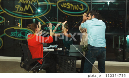 Group of businesspeople gives high five together at glass wall. Tracery 110324756