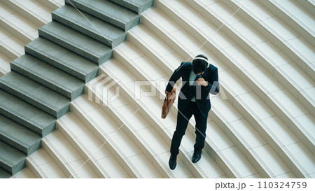 Happy business man listening to music from headphone while walking. Exultant. 110324759