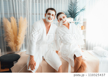 Blissful couple in bathrobe with facial cream mask. Quiescent 110325437