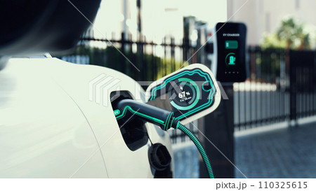 Electric car recharge to charging station at car park display hologram. Peruse Electric car recharge to charging station at car park display hologram. Peruse 110325615