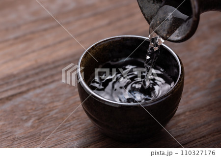 日本酒をお猪口に注ぐ 110327176