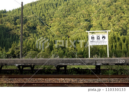 東北内陸部 駅のプラットホーム、駅名板、線路と山並み 東北内陸部 駅のプラットホーム、駅名板、線路と山並み 110330133