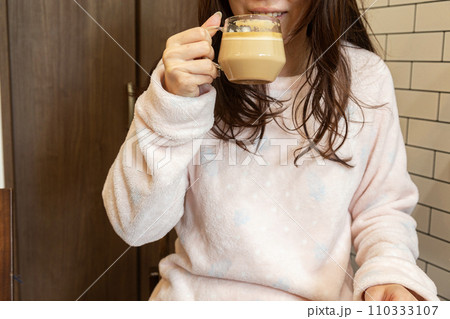 朝食後にパジャマでカフェラテを飲む女性 朝食後にパジャマでカフェラテを飲む女性 110333107