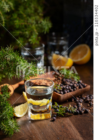 Gin with ingredients on an old wooden table. Gin with ingredients on an old wooden table. 110334402