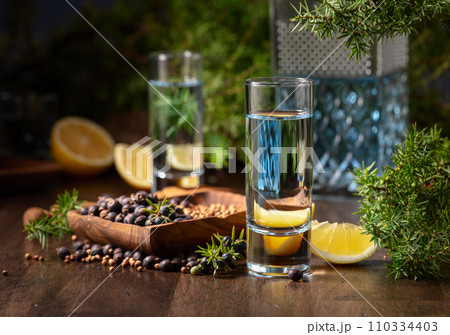 Gin with ingredients on an old wooden table. Gin with ingredients on an old wooden table. 110334403