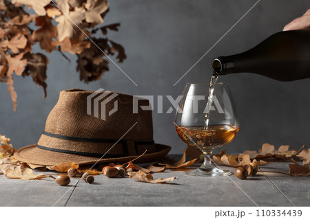 Brandy is poured from a bottle into a glass. 110334439