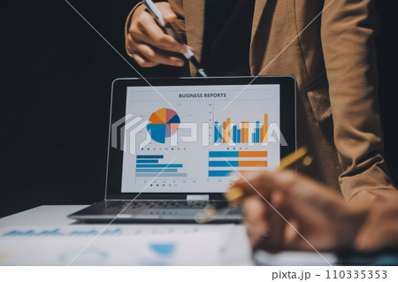 Financial analysts analyze business financial reports on a digital tablet planning investment project during a discussion at a meeting of corporate showing the results of their successful teamwork. 110335353