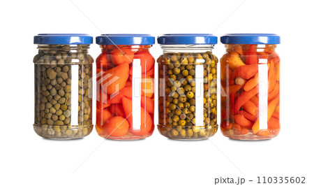 Pickled spices in small glass jars. From left to right capers, hot red baby peppers, green peppercorns, and piri piri chilis. Pasteurized and preserved in a brine of water, vinegar and salt. Photo. Pickled spices in small glass jars. From left to right capers, hot red baby peppers, green peppercorns, and piri piri chilis. Pasteurized and preserved in a brine of water, vinegar and salt. Photo. 110335602