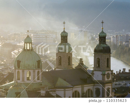 Bell towers of Cathedral of St. James in Innsbruck, Austria. Church Domes in Soaft Light at Foggy Evening sunset time 110335623