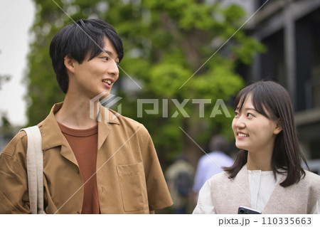 笑顔で会話する大学生の男女 笑顔で会話する大学生の男女 110335663