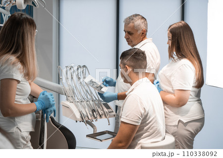 Dentists conduct a collective examination of the X-ray, confident that together they will be able to find the best solution for the patient. A group of experts in the field of dentistry takes a deep 110338092