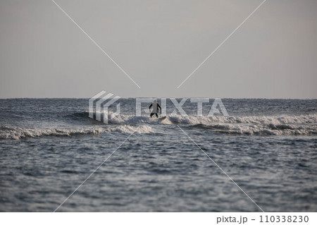 沖縄の海でサーフィンをするサーファー 沖縄の海でサーフィンをするサーファー 110338230