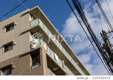 集合住宅のベランダに干された布団 110338413
