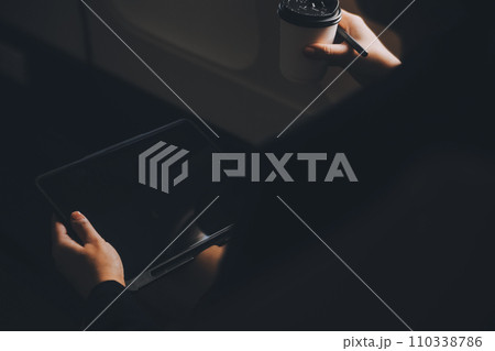 Blonde female tourist checking incoming notification on smartphone sitting on seat of airplane with netbook.Young businesswoman share media from telephone on laptop computer during plane flight Blonde female tourist checking incoming notification on smartphone sitting on seat of airplane with netbook.Young businesswoman share media from telephone on laptop computer during plane flight 110338786