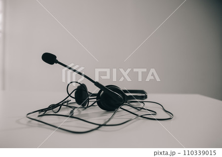 Communication support, call center and customer service help desk. VOIP headset on telephone keyboard. 110339015